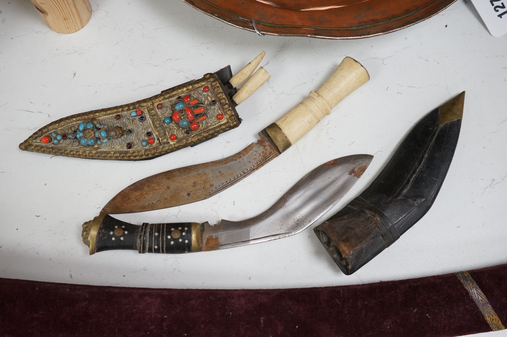 An Indian Tulwar sword, in scabbard and two small kukri, largest 93cm long.